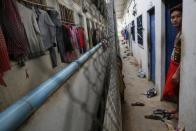 Un hombre se apoya en el quicio de la puerta de una habitación situada en el edificio donde viven los trabajadores textiles. (Reuters/Damir Sagolj).