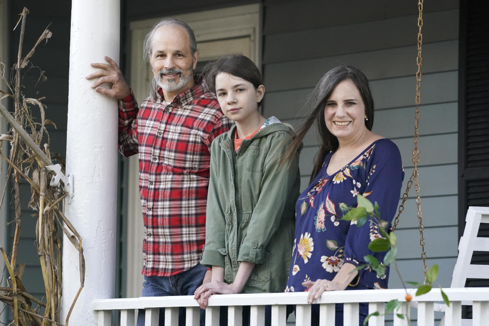 Olivia Chaffin, center, stands for a portrait with her parents, Doug, left, and Kim Chaffin, at their home in Jonesborough, Tenn., on Nov. 1, 2020. Olivia, who stopped selling Girl Scout cookies because they contain palm oil says, "I'm not just some little girl who can't do anything about this. … Children can make change in the world. And we're going to." (AP Photo/Mark Humphrey)