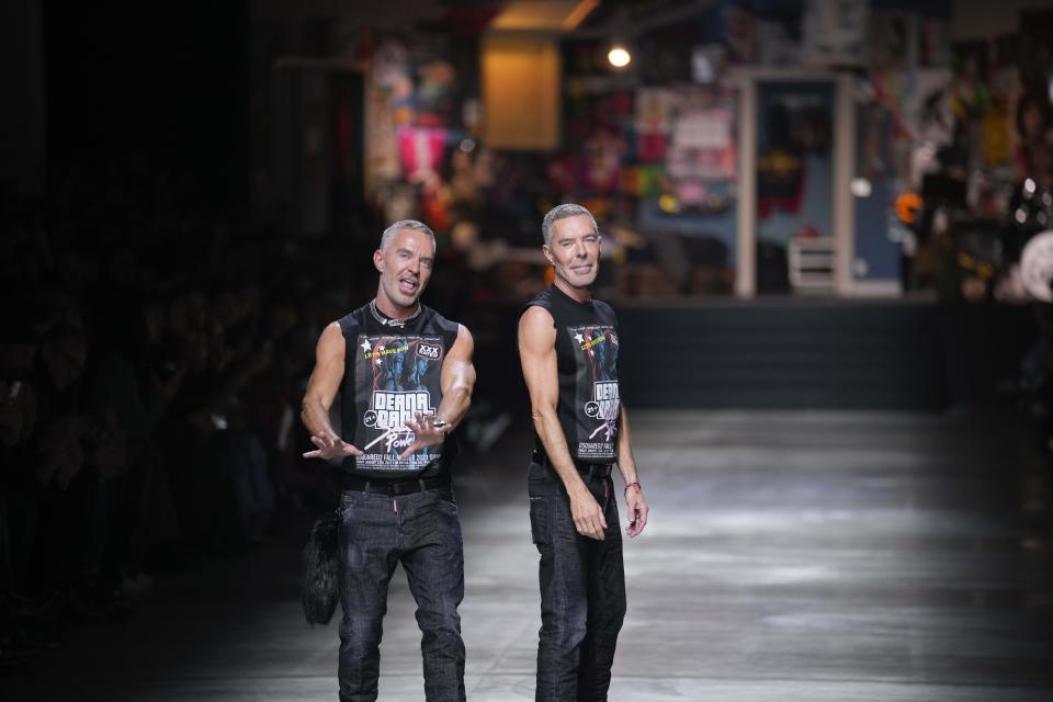 Dean and Dan Caten greets the spectators at the end of the DSquared2 menswear Fall-Winter 2023-24 collection presented in Milan, Italy, Friday, Jan. 13, 2023. (AP Photo/Antonio Calanni)