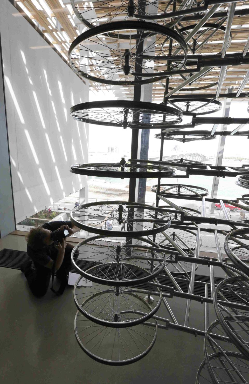 A photographer gets a low angle on a work titled "Stacked" by artist Ai Weiwei of China during a media tour of the PAMM in Miami, Florida