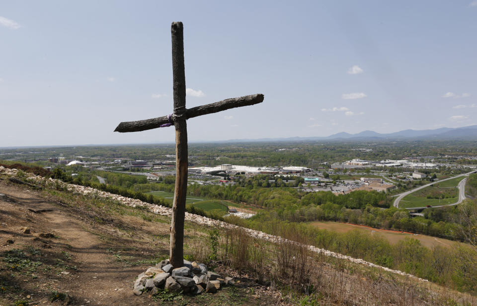 FILE - A cross erected on Candlers Mountain overlooks Liberty University in Lynchburg, Va., Tuesday, April 21, 2015. Originally from Florida, Joshua Mast, who would be come a Marine Corps attorney, married his wife, Stephanie, and attended the evangelical Christian college. (AP Photo/Steve Helber, File)