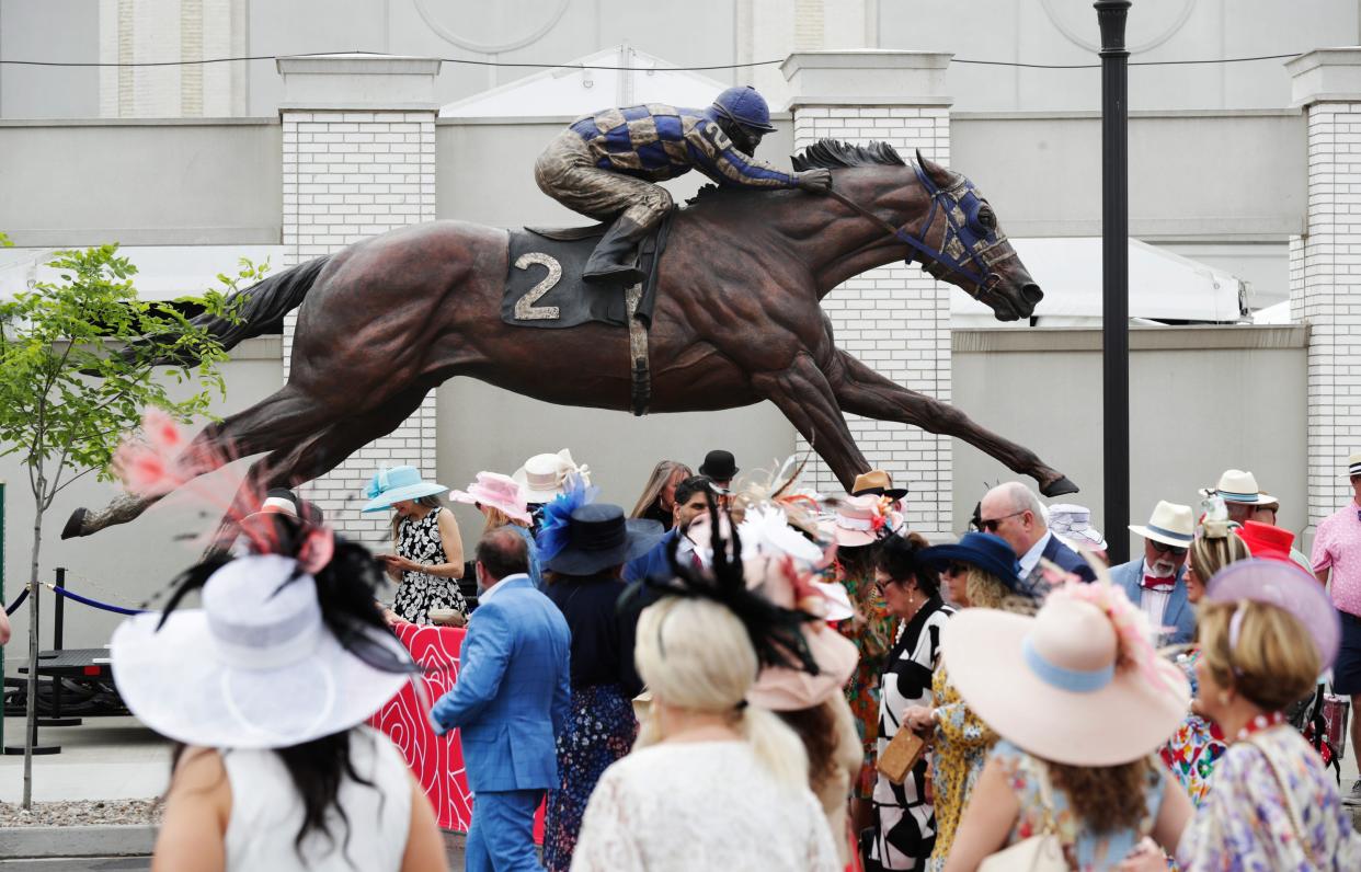 Race fans enter the track beneath the statue of Secretariat on Kentucky Derby Day at Churchill Downs in Louisville, Ky. on May 6, 2023.