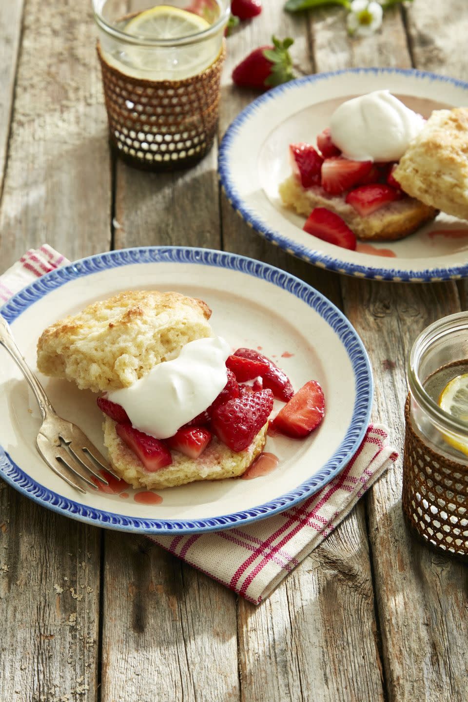 brandied strawberry shortcakes with malted whipped cream on plates with forks