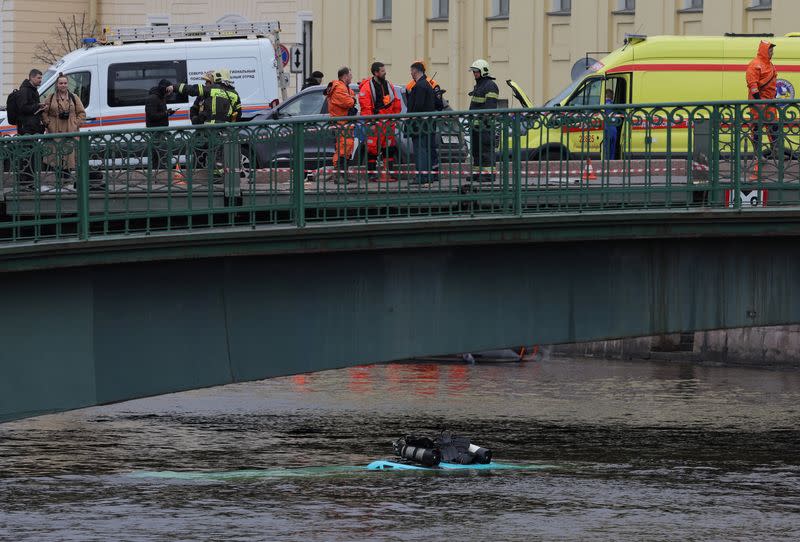 Rescuers work at the site where a bus fell into a river in Saint Petersburg