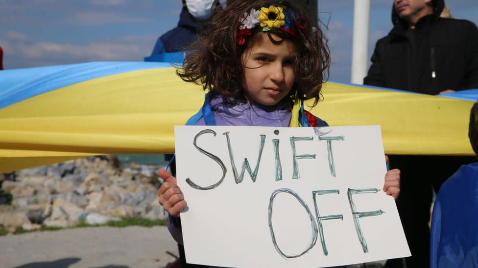 Niña sujeta un cartel para excluir a Rusia del SWIFT
