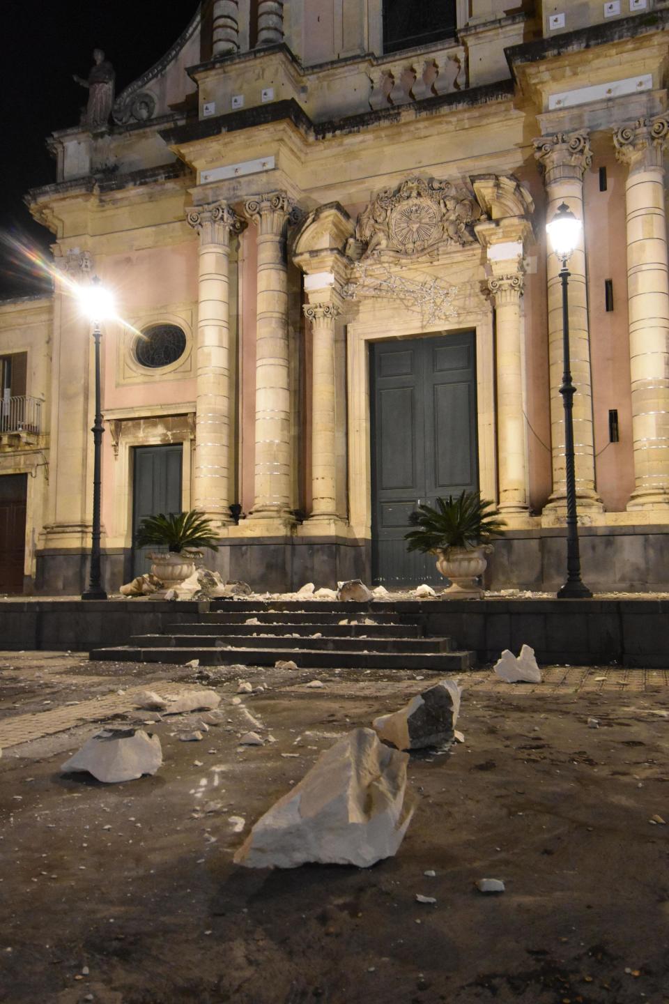 Debris stand in front of the damaged Sacro Cuore (Holy Heart) Church in Santa Venerina, Sicily Italy, Wednesday, Dec. 26, 2018. A quake triggered by Italy's Mount Etna volcano has jolted eastern Sicily, slightly injuring 10 people and prompting frightened Italian villagers to flee their homes. (Orietta Scardino/ANSA Via AP)