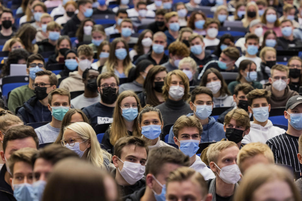 Students wear mouth-to-nose coverings while sitting close to each other during the lecture "BWL 1" in lecture hall H1 of the Westfaelische Wilhelms-Universitaet in Muenster, Germany, Monday, Oct. 11, 2021. For the first time since the beginning of the Corona pandemic, lectures in the winter semester 21/22 have started in presence under 3G conditions. (Rolf Vennenbernd/dpa via AP)