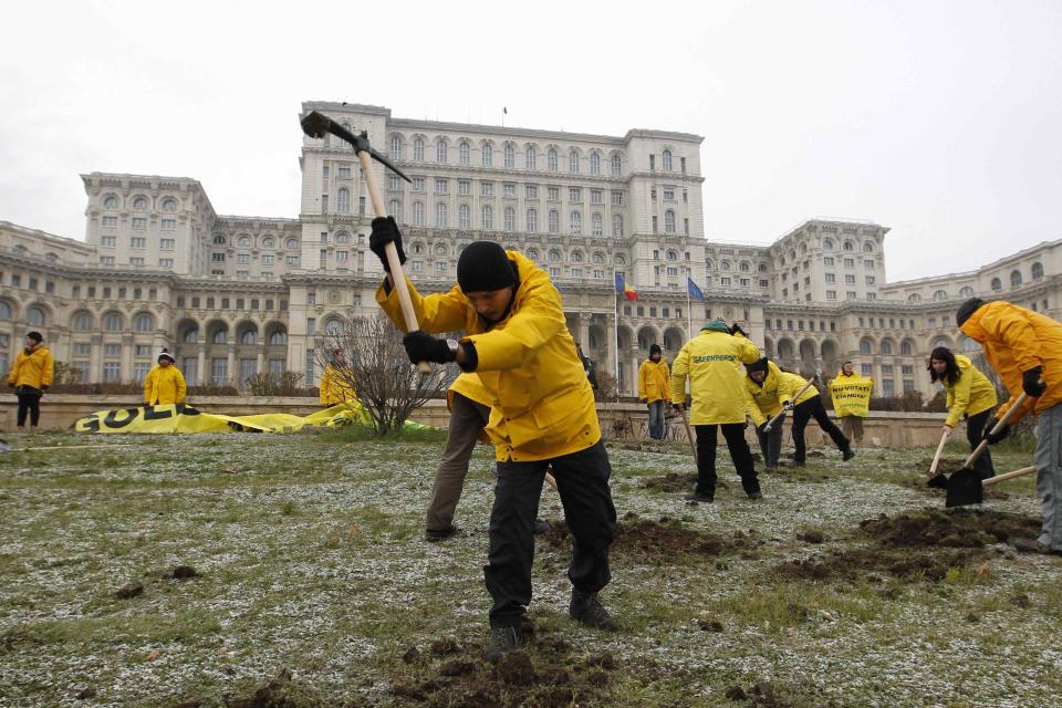 Greenpeace activists dig into the yard of Romania's Parliament, to protest against a Canadian company's plan to set up Europe's biggest open-cast gold mine in Romania, in Bucharest December 9, 2013. A special Romanian parliament commission overwhelmingly rejected a draft bill that would have allowed Canada's Gabriel Resources to set up Europe's biggest open-cast gold mine in the small Carpathian town of Rosia Montana last month. However, parliament plans to revise a mining law that could open way for the project. REUTERS/Bogdan Cristel (ROMANIA - Tags: ENVIRONMENT POLITICS BUSINESS TPX IMAGES OF THE DAY)