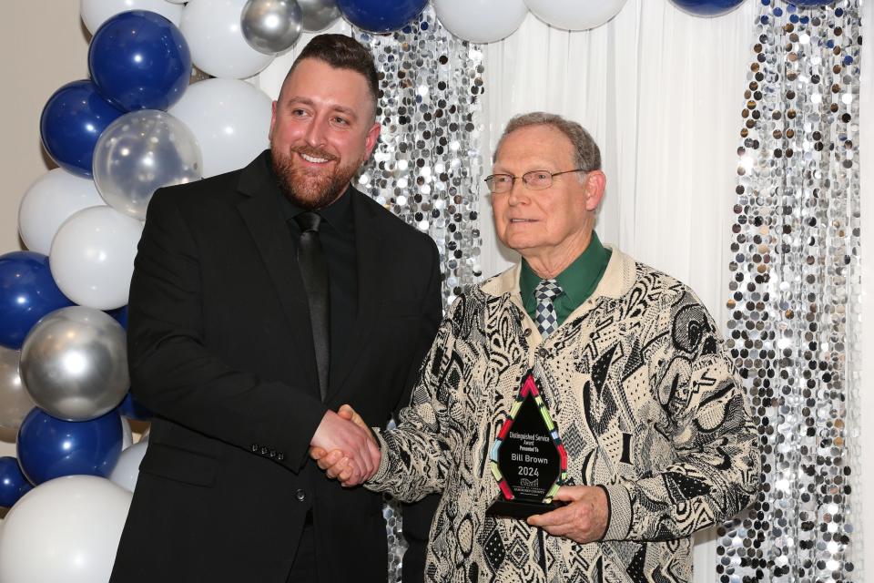 Sandusky County Chamber of Commerce CEO Tyler Kneeskern congratulates Bill Brown, winner of the 2024 Distinguished Service Award.