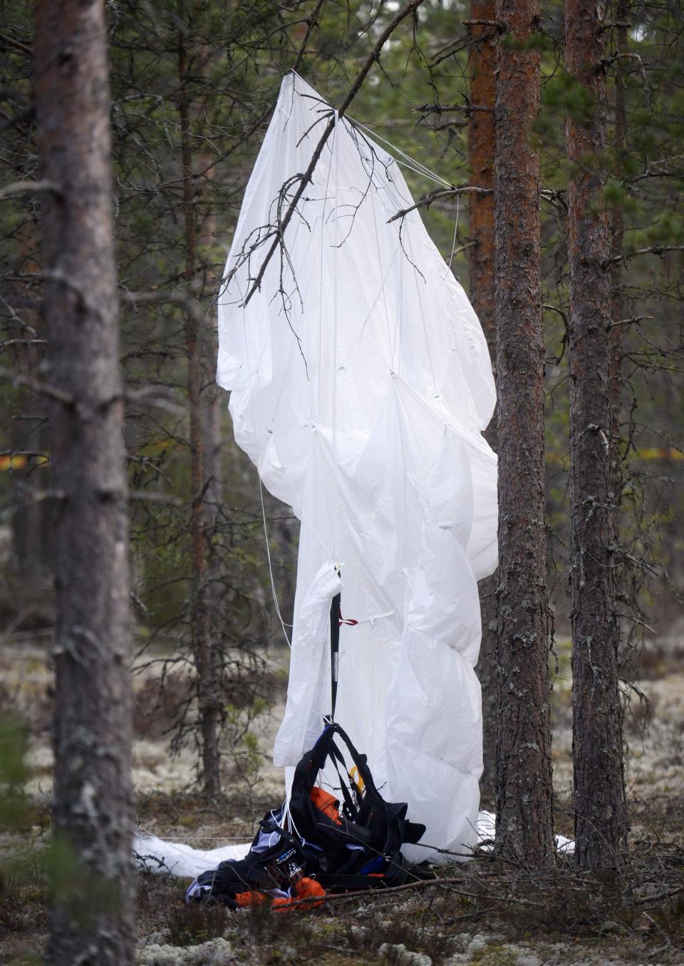 A parachute hangs from tree close to the wreckage of an aircraft next to Jamijarvi Airfield, southwest Finland on Monday April 21, 2014. Finnish officials on Sunday eight people died when a small plane carrying parachutists crashed to the ground and caught fire. (AP Photo/LEHTIKUVA /Vesa Moilanen) FINLAND OUT