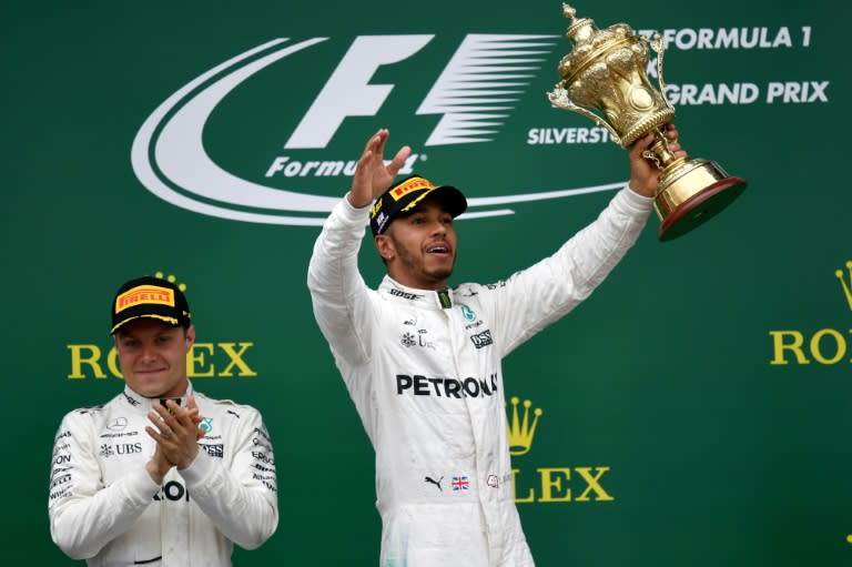 Mercedes' British driver Lewis Hamilton (right) celebrates next to second-placed Mercedes' Finnish driver Valtteri Bottas after winning the British Formula One Grand Prix in Silverstone on July 16, 2017