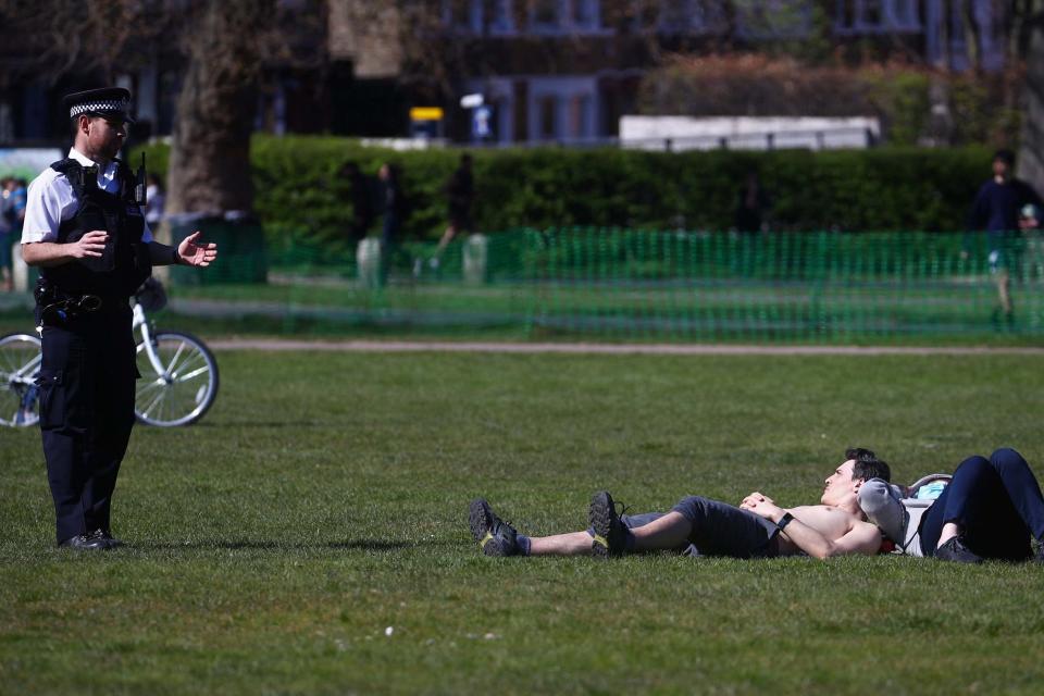 A police officer speaks with people in Greenwich Park (REUTERS)