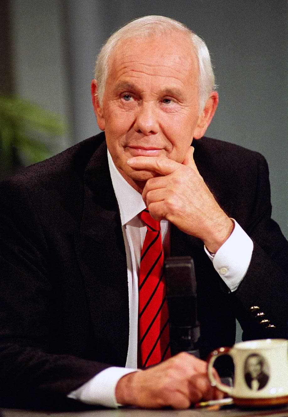 FILE - This May 22, 1992 file photo shows talk show host Johnny Carson, with his personalized coffee cup in front of him, watching clips from earlier shows during the last taping of the "Tonight Show" in front of family and friends in Burbank, Calif. (AP Photo/Douglas C. Pizac, file)