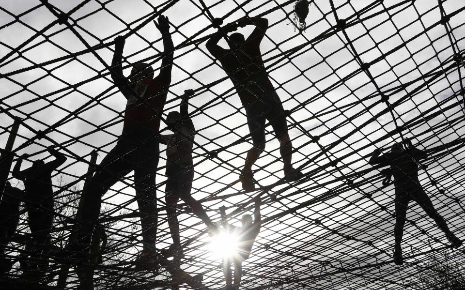 Competitors climb cargo net during the Tough Guy event in Perton