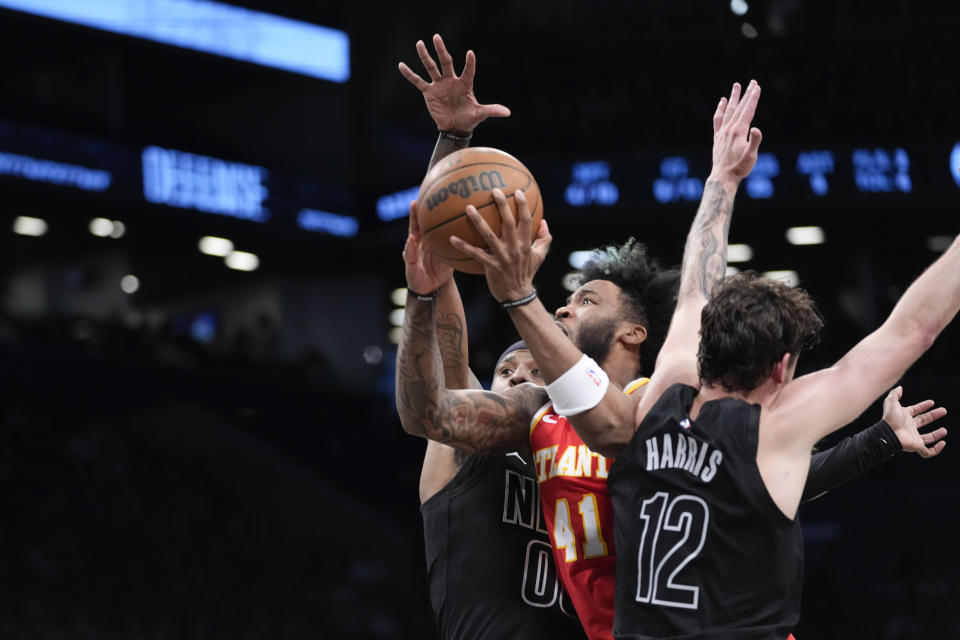 Atlanta Hawks forward Saddiq Bey (41) goes to the basket against Brooklyn Nets forward Joe Harris (12) and forward Royce O'Neale during the first half of an NBA basketball game Friday, March 31, 2023, in New York. (AP Photo/Mary Altaffer)