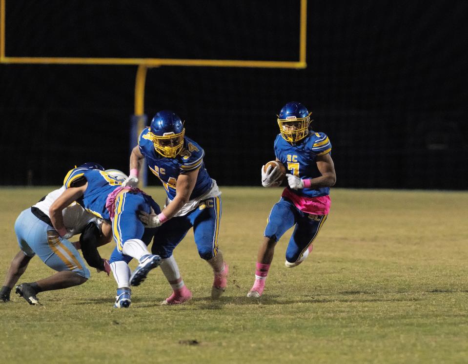 Sussex Central's William Harmon (7) finds a hole with a block from Anthony Taylor (54) in their home game against Cape Henlopen in Georgetown, Del.