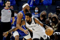 Brooklyn Nets guard Kyrie Irving, right, tries to get past Minnesota Timberwolves forward Josh Okogie (20) in the first quarter of an NBA basketball game, Sunday, Jan. 23, 2022, in Minneapolis. (AP Photo/Bruce Kluckhohn)