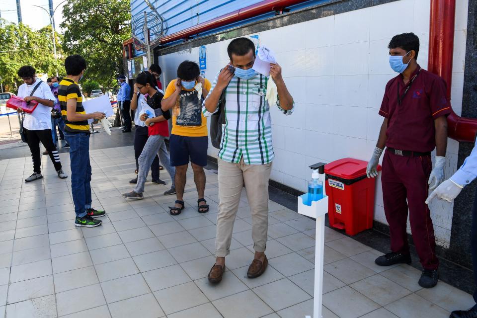 Students wear facemasks as they arrive at an examination centre for Joint Entrance Examination (JEE ) Main-2020, one of the most competitive entrance exams for entry to top national engineering colleges, in Noida on September 1, 2020. (Photo by PRAKASH SINGH/AFP via Getty Images)