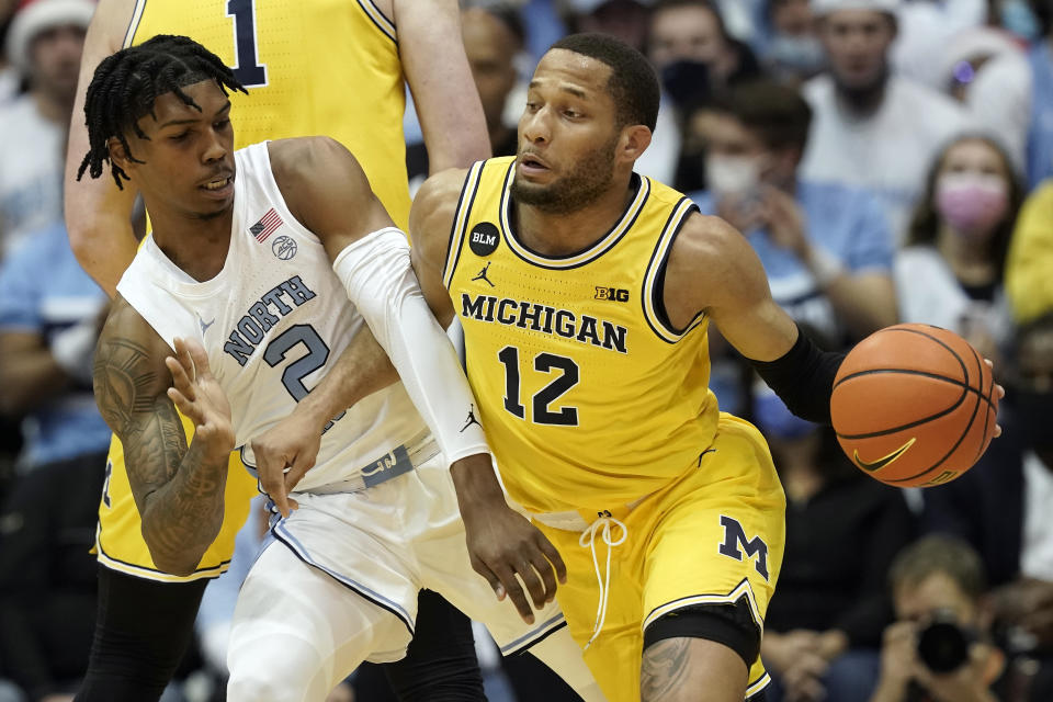 North Carolina guard Caleb Love (2) guards Michigan guard DeVante' Jones (12) during the first half of an NCAA college basketball game in Chapel Hill, N.C., Wednesday, Dec. 1, 2021. (AP Photo/Gerry Broome)