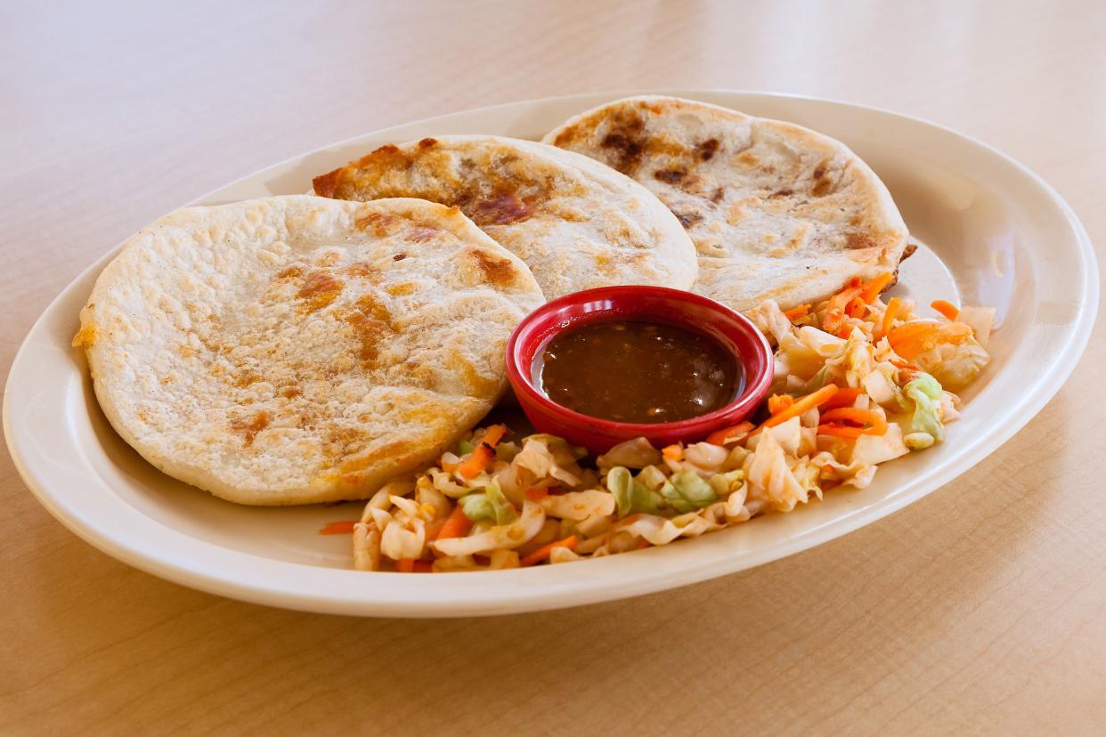 pupusas on plate with slaw and red sauce