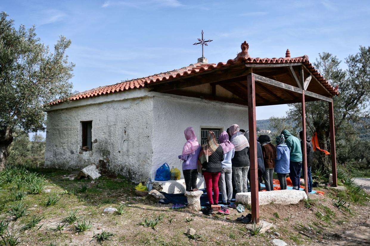 A picture taken on March 16, 2017 shows African Christian migrants praying at a hill church near the Moria migrant camp on the island of Lesbos, Greece. (Photo: LOUISA GOULIAMAKI via Getty Images)