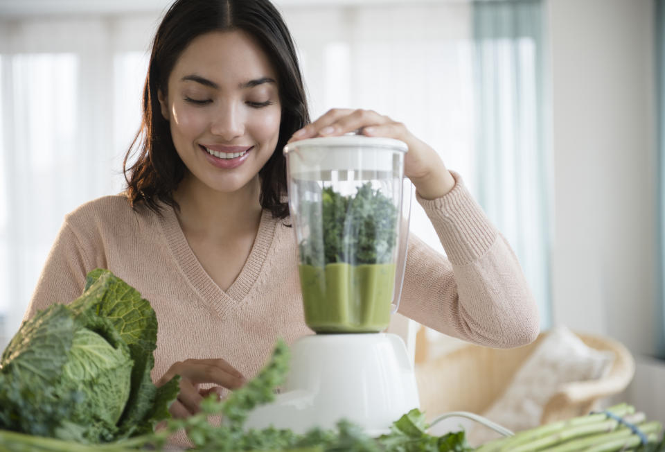 Frau mixt grünen Smoothie