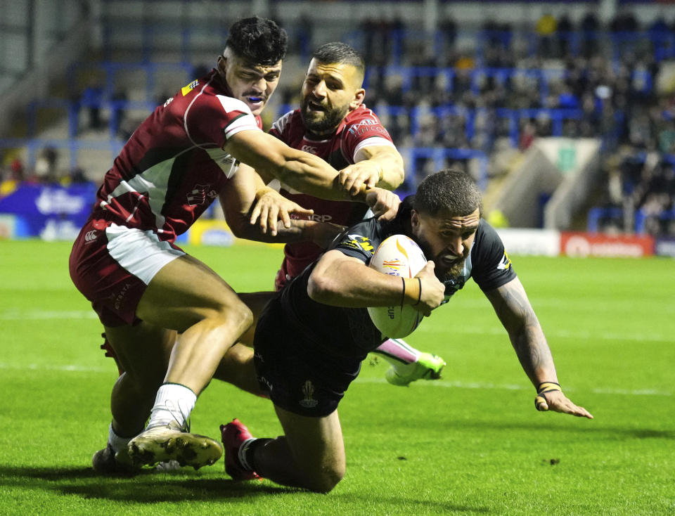 New Zealand's Kenny Bromwich, foreground, scores a try as Lebanon's players challenges him during the Rugby League World Cup match between New Zealand and Lebanon at the Halliwell Jones Stadium in Warrington, England, Sunday, Oct. 16, 2022. (AP Photo/Jon Super)