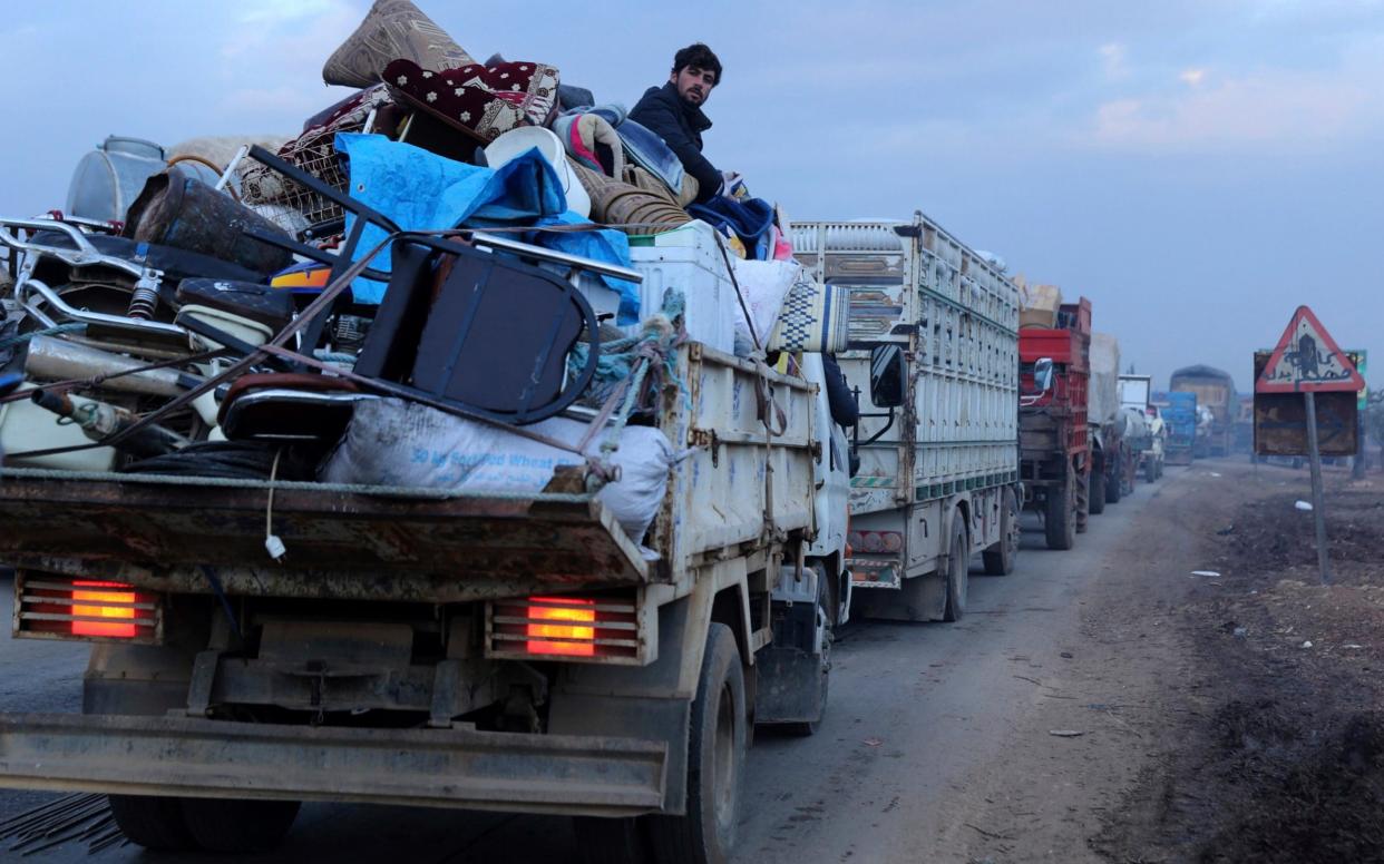 A man rides in a truck as civilians flee a Syrian military offensive in Idlib province on the main road near Hazano, Syria - AP