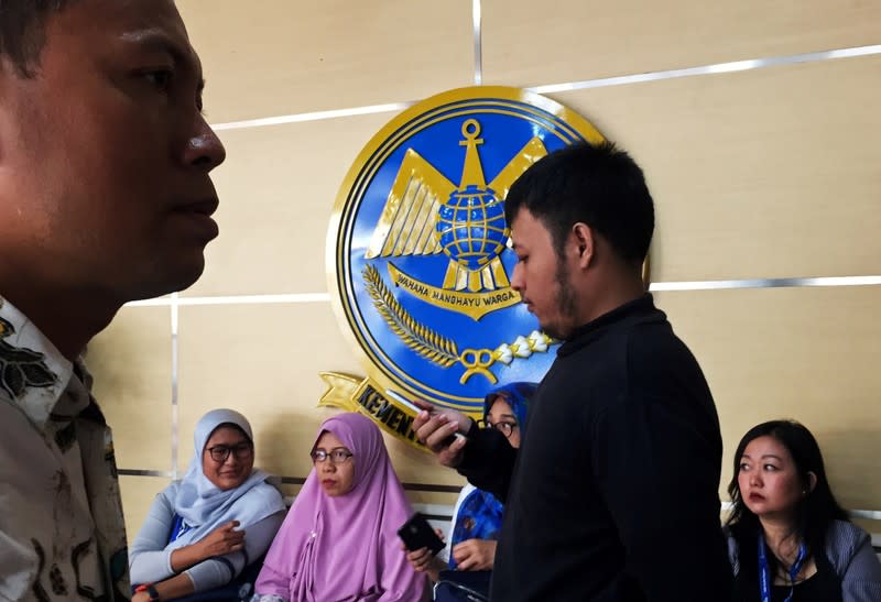 Family members of the victims killed in the crash of Lion Air flight JT610 sit in the lobby of the Transport Ministry ahead of the briefing to the families of victims on the final report on the crash in Jakarta