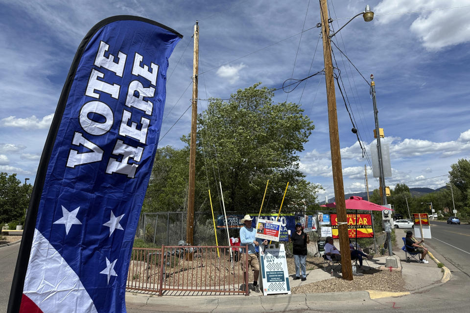 Political campaign supporters greet voters as they turn into a polling location in Santa Fe, N.M., Tuesday, June 4, 2024. New Mexico voters were picking their partisan favorites in the state's primary election to reshape a Democratic-led Legislature, with all 112 seats up for election in November. (AP Photo/Morgan Lee)