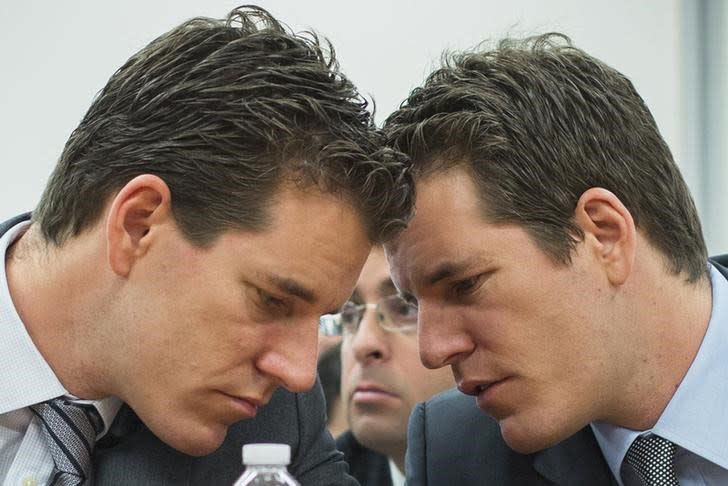 Brothers Cameron (L) and Tyler Winklevoss talk to each other as they attend a New York State Department of Financial Services (DFS) virtual currency hearing in the Manhattan borough of New York January 28, 2014. REUTERS/Lucas Jackson