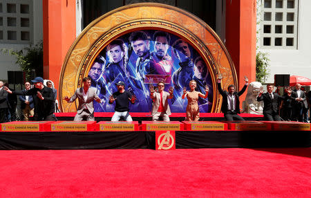 Actors Robert Downey Jr., Chris Evans, Mark Ruffalo, Chris Hemsworth, Scarlett Johansson, Jeremy Renner and Marvel Studios President Kevin Feige pose on the stage after placing their handprints in cement at a ceremony at the TCL Chinese Theatre in Hollywood, California, U.S. April 23, 2019. REUTERS/Mario Anzuoni