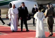 Pope Francis, left, is welcomed by Kurdish President Nechirvan Barzani, second from left , upon his arrival to Irbil airport, Iraq, Sunday, March 7, 2021. Pope Francis arrived in northern Iraq on Sunday, where he planned to pray in the ruins of churches damaged or destroyed by Islamic State extremists and celebrate an open-air Mass on the last day of the first-ever papal visit to the country. (AP Photo/Hadi Mizban)