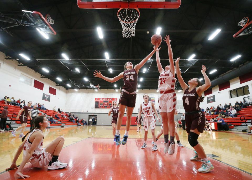 Woodridge's Cameron Hoover and Springfield's Sydney Hillyard go for a rebound as Springfield's Kayla Gaspar and Kendall Wilderman and Woodridge's Anna Rorrer and Sarah Rathburn look on Jan. 17 at Springfield.