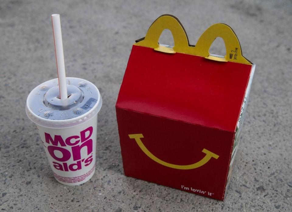 McDonald's Happy Meal box with a drink on pavement