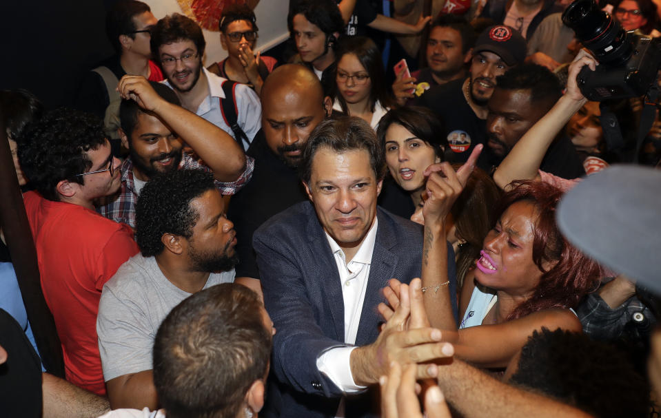 Brazil's presidential candidate for the Workers Party Fernando Haddad greets students during a meeting, in Sao Paulo, Brazil, Wednesday, Sept. 12, 2018. Haddad met with university students who benefited from an affirmative action program for underprivileged youth and racial minorities put in place during the presidency of Luiz Inacio Lula da Silva. Brazil will hold general elections on Oct. 7. (AP Photo/Andre Penner)