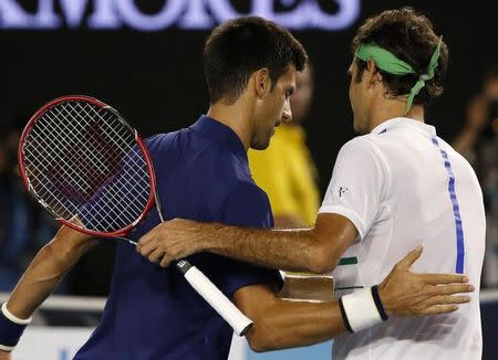 Serbia's Novak Djokovic (L) pats Switzerland's Roger Federer on the back after winning their semi-final match at the Australian Open tennis tournament at Melbourne Park, Australia, January 28, 2016. REUTERS/Issei Kato
