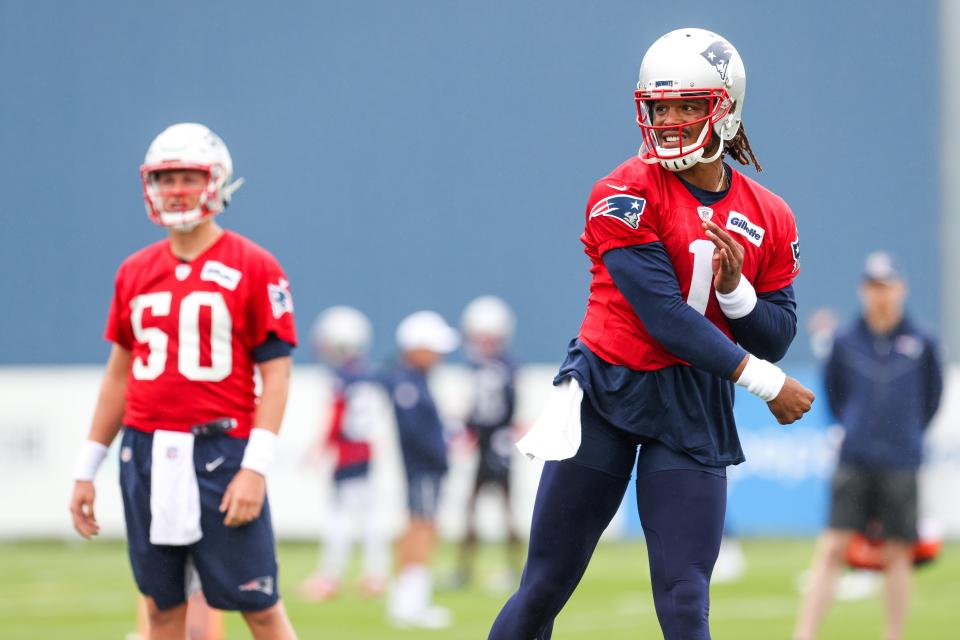 New England Patriots quarterback Mac Jones (50) watches New England Patriots quarterback Cam Newton (1) during training camp at Gillette Stadium.