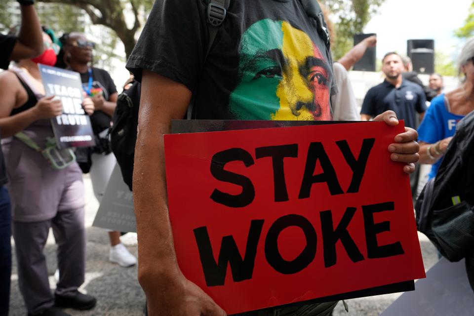 A person carries a Stay Woke sign during the "Teach No Lies" march Aug. 16, 2023 to the School Board of Miami-Dade County to protest Florida's new standards for teaching Black history.