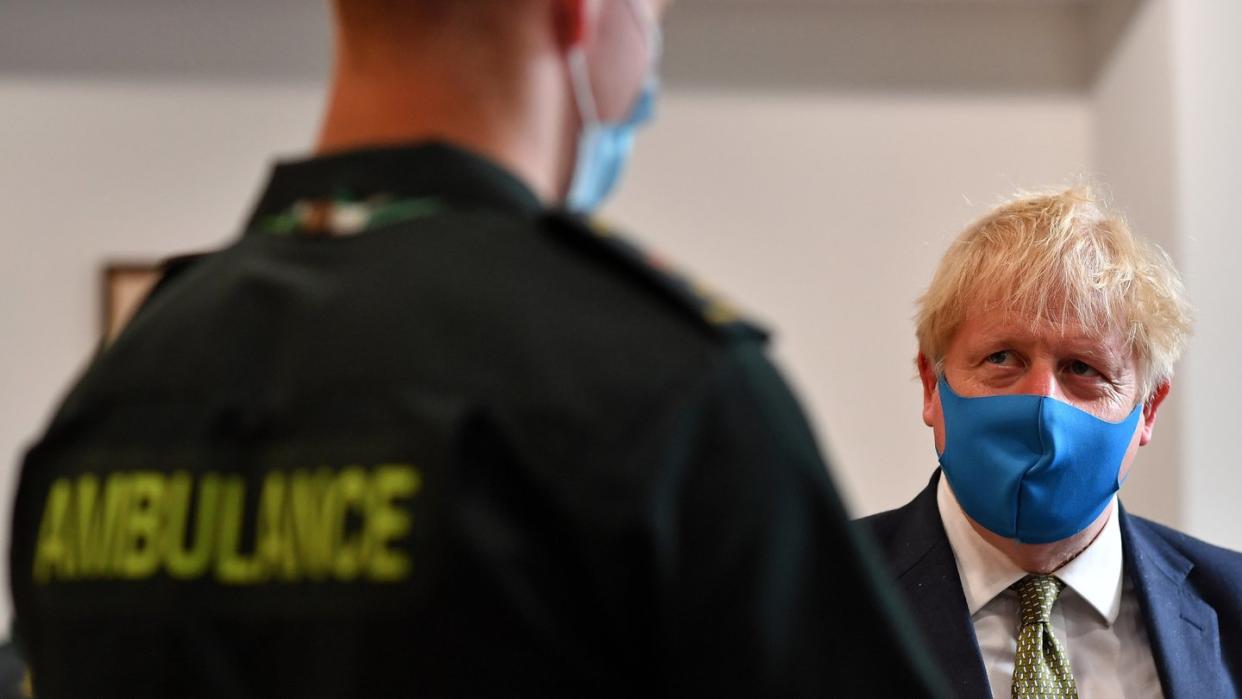 Premier Boris Johnson spricht während eines Besuchs im Hauptquartier des London Ambulance Service NHS Trust mit einem Sanitäter.