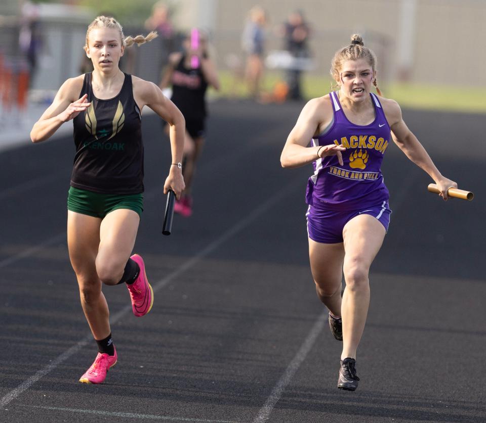 GlenOak's Sydney Stepanovich (left) and Jackson's Emily Adams come down to the finish line in the 800-meter relay at Friday's Division I district track and field meet.