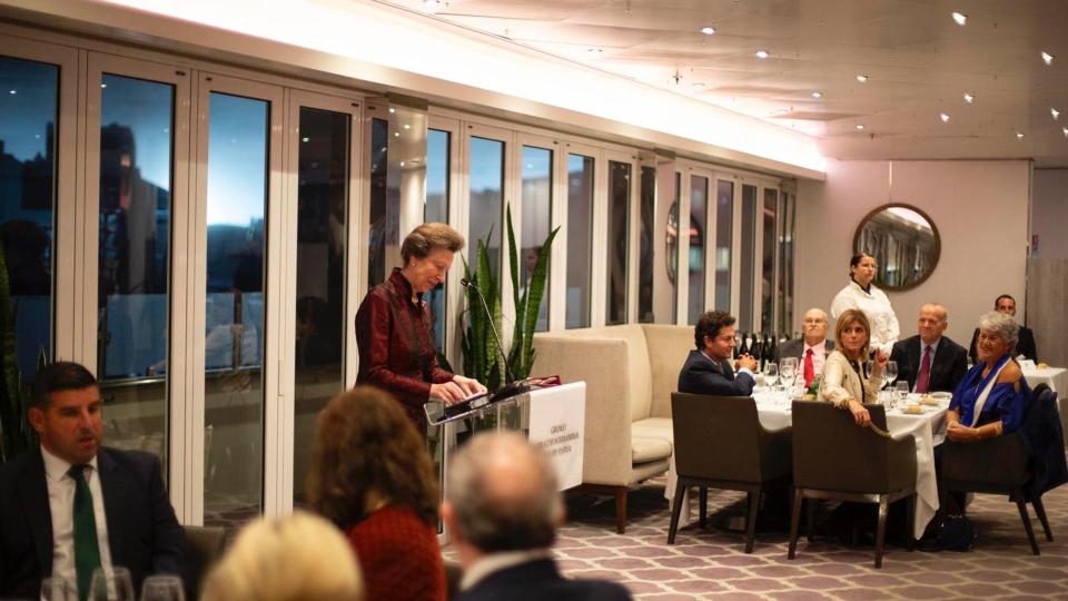 The Princess Royal in red dress giving speech