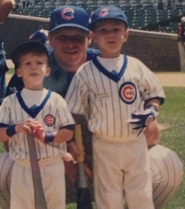 Cam Sanders, left, with his brother Scottie and their father Scott during family day at Wrigley Field in 1999.