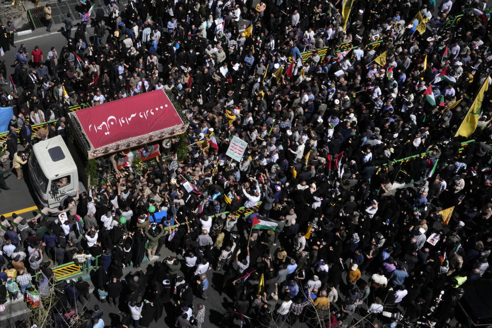 Miles de iraníes rodean el camión que traslada los ataúdes de los integrantes de la Guardia Revolucionaria que murieron en un ataque aéreo atribuido a Israel que destruyó la sección consular de la embajada iraní en Siria el lunes, en un cortejo fúnebre en Teherán, Irán, el viernes 5 de abril de 2024. (AP Foto/Vahid Salemi)