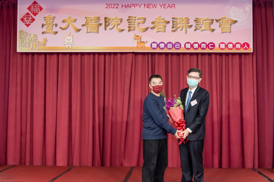 台大癌醫中心分院副院長陳晉興（右）上台獻花，恭喜患者接受手術後重生。（圖／台大醫院提供）