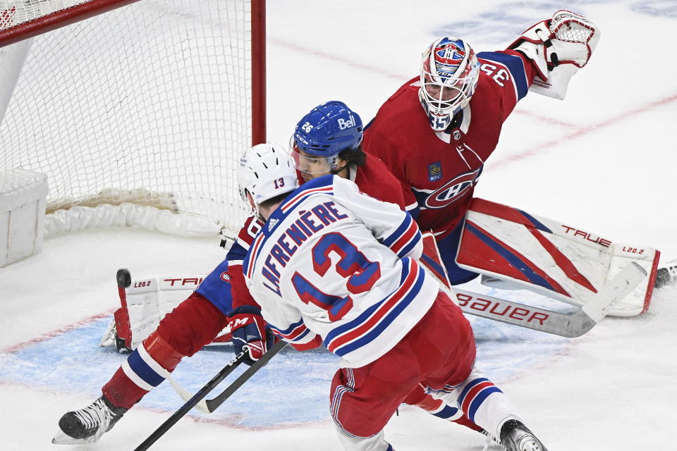 New York Rangers' Alexis Lafreniere (13) shoots on Montreal Canadiens goaltender Sam Montembeault as Canadiens' Johnathan Kovacevic (26) defends during the second period of an NHL hockey game Thursday, March 9, 2023, in Montreal. (Graham Hughes/The Canadian Press via AP)