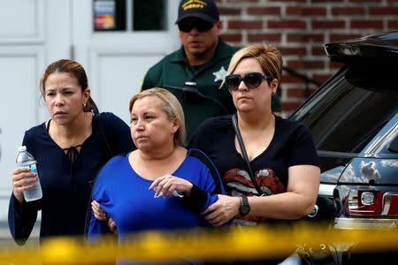 Family members help a woman out of a senior citizen's center after being notified of the fate of their loved ones, one day after a mass shooting at the Pulse gay night club in Orlando, Florida, U.S., June 13, 2016. REUTERS/Adrees Latif