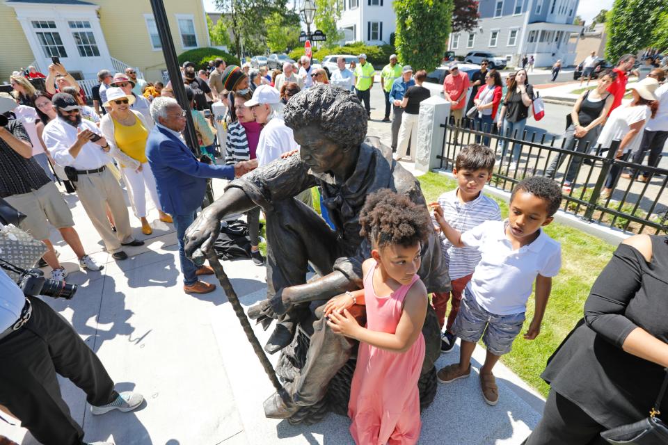 People take a closer look at the Frederick Douglass statue which was unveiled at the Abolition Row Park dedication in New Bedford.