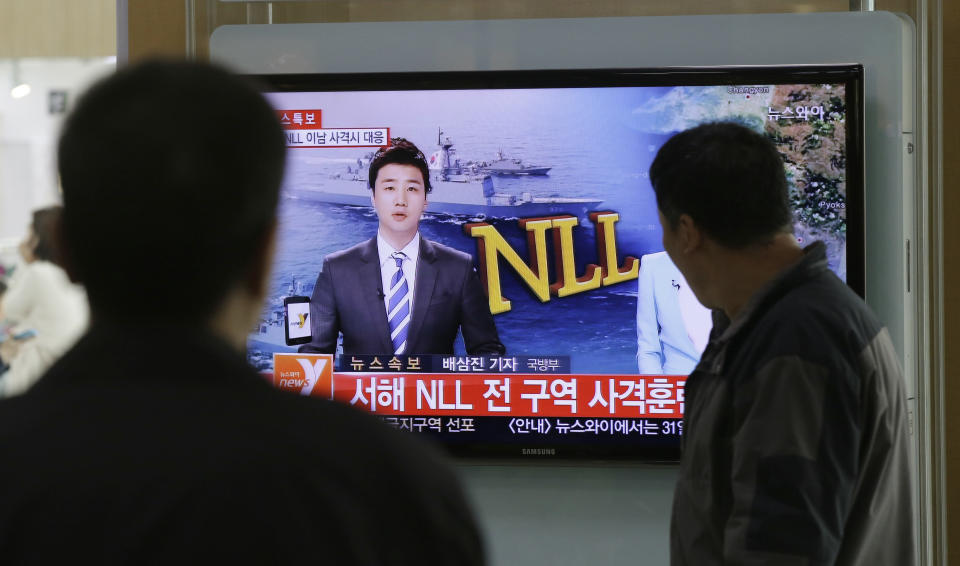 People watch a television news program reporting about North Korea's plan to conduct live-fire drills, at a Seoul train station in Seoul, South Korea, Monday, March 31, 2014. South Korea said North Korea has announced plans to conduct live-fire drills near the rivals' disputed western sea boundary. Seoul's Defense Ministry said North Korea says it will conduct firing drills in seven areas north of the sea boundary. The letters read "Western Sea NLL (Northern Limit Line) Firing drills." (AP Photo/Lee Jin-man)