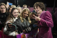 Timothee Chalamet, derecha, posa para retratos con fans a su llegada a la premiere mundial de la película "Wonka" el martes 28 de noviembre de 2023 en Londres. (Scott Garfitt/Invision/AP)